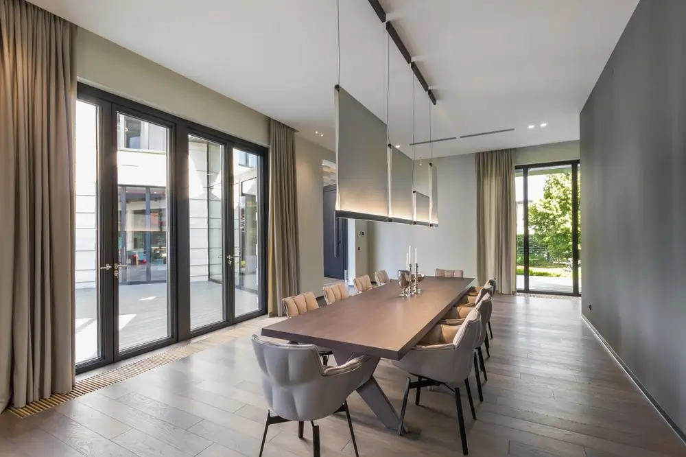 Une salle à manger moderne avec une grande table et des chaises élégantes.