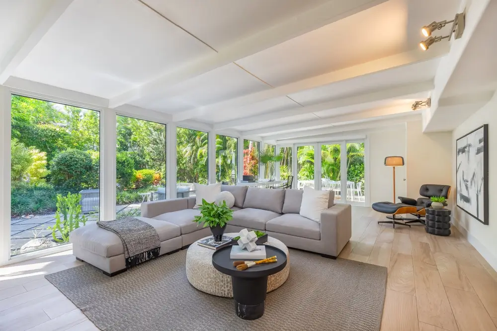 Un salon lumineux avec une grande fenêtre et un canapé confortable.
